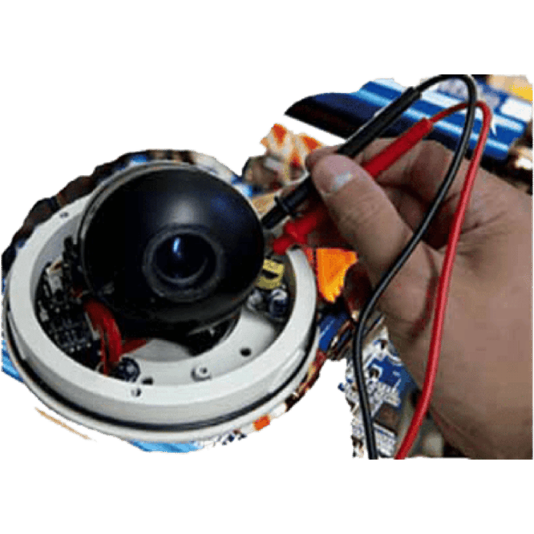 Hand holding red and black wires near a disassembled security camera module during repair/installation.