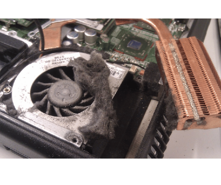 Internal view of a laptop cooling system: a dusty fan and heatsink with a copper heat pipe visible on the motherboard edge.