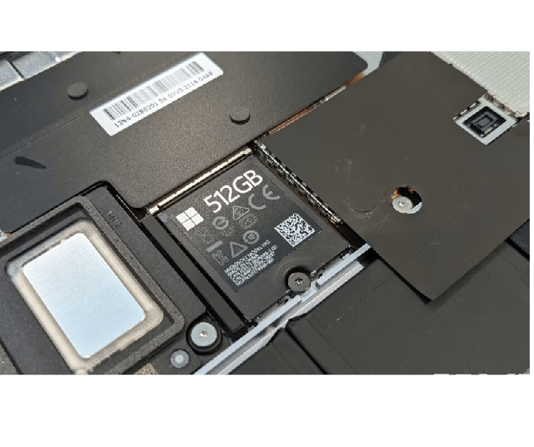 Close-up of a 512GB SSD inside a laptop, showing the label and surrounding components of the drive bay