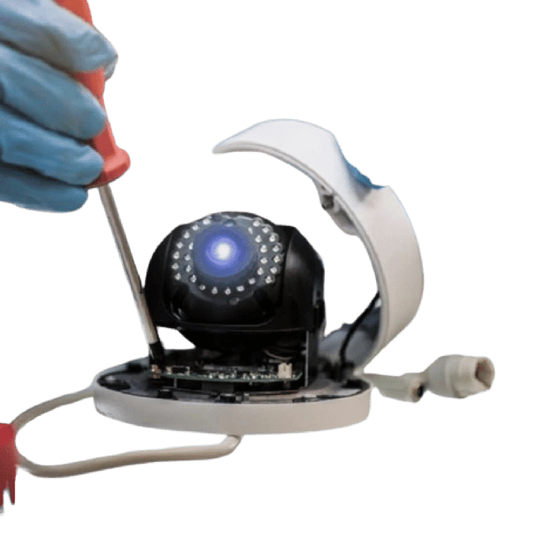 Dome security camera with housing opened, a gloved hand uses a screwdriver to access the internals.
